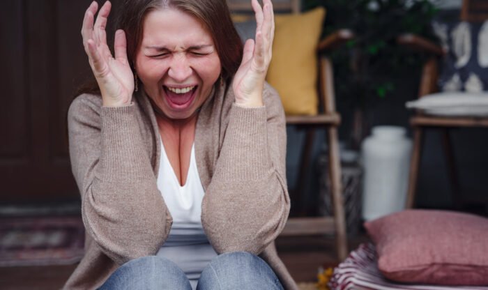 middle aged depressed woman sitting on porch. She feeling sad and worried suffering depression in mental health. Problems and broken heart concept. Negative human emotion with cry of pain