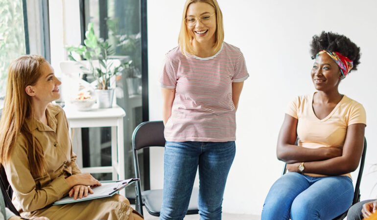 Group psychotherapy. Persons sitting in circle and talking. People meeting. Psychotherapy training, business lecture or conference. Man woman support group. Young businesspeople having a meeting in the office, young businesswoman entrepreneur